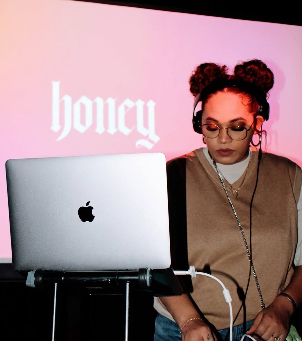 Lady CoCo DJing at Honey under a pink screen