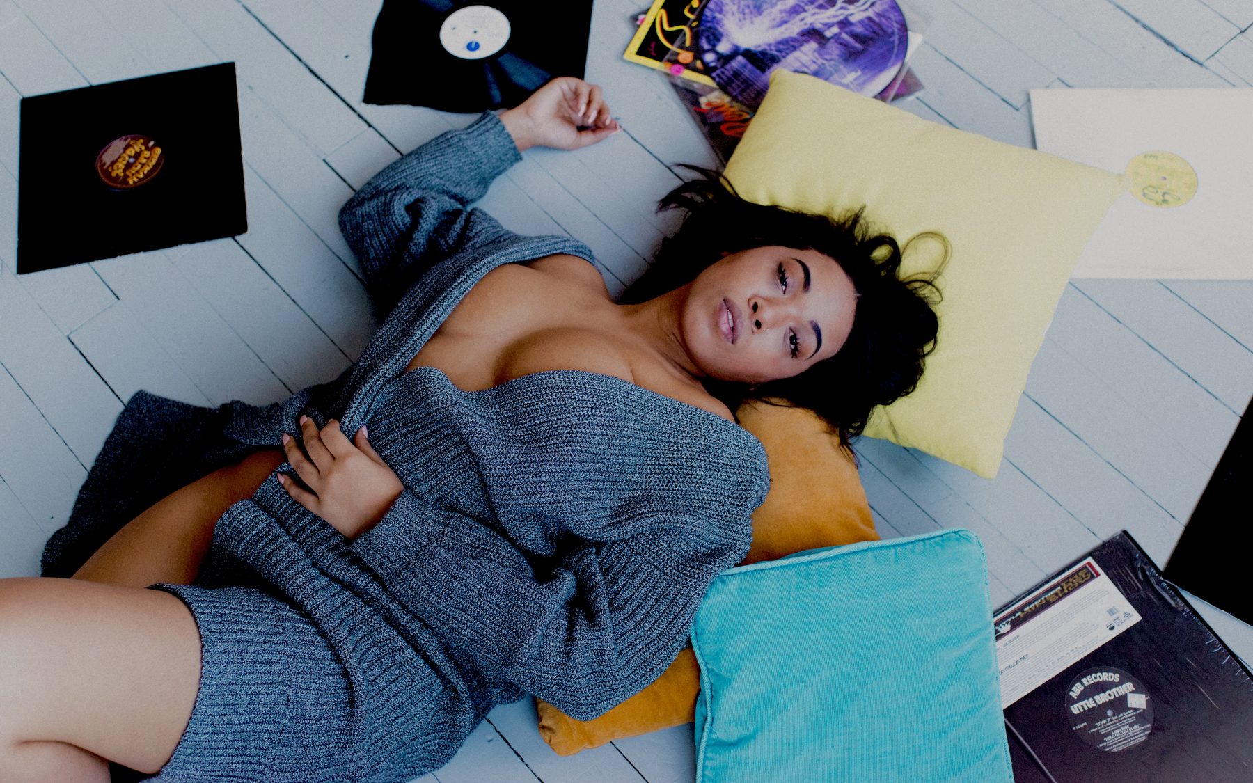 Myeka on the floor surrounded by her records
